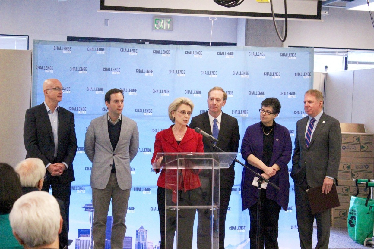 Six leaders stand at a podium during a 2016 press conference announcing the Mobility Innovation Center